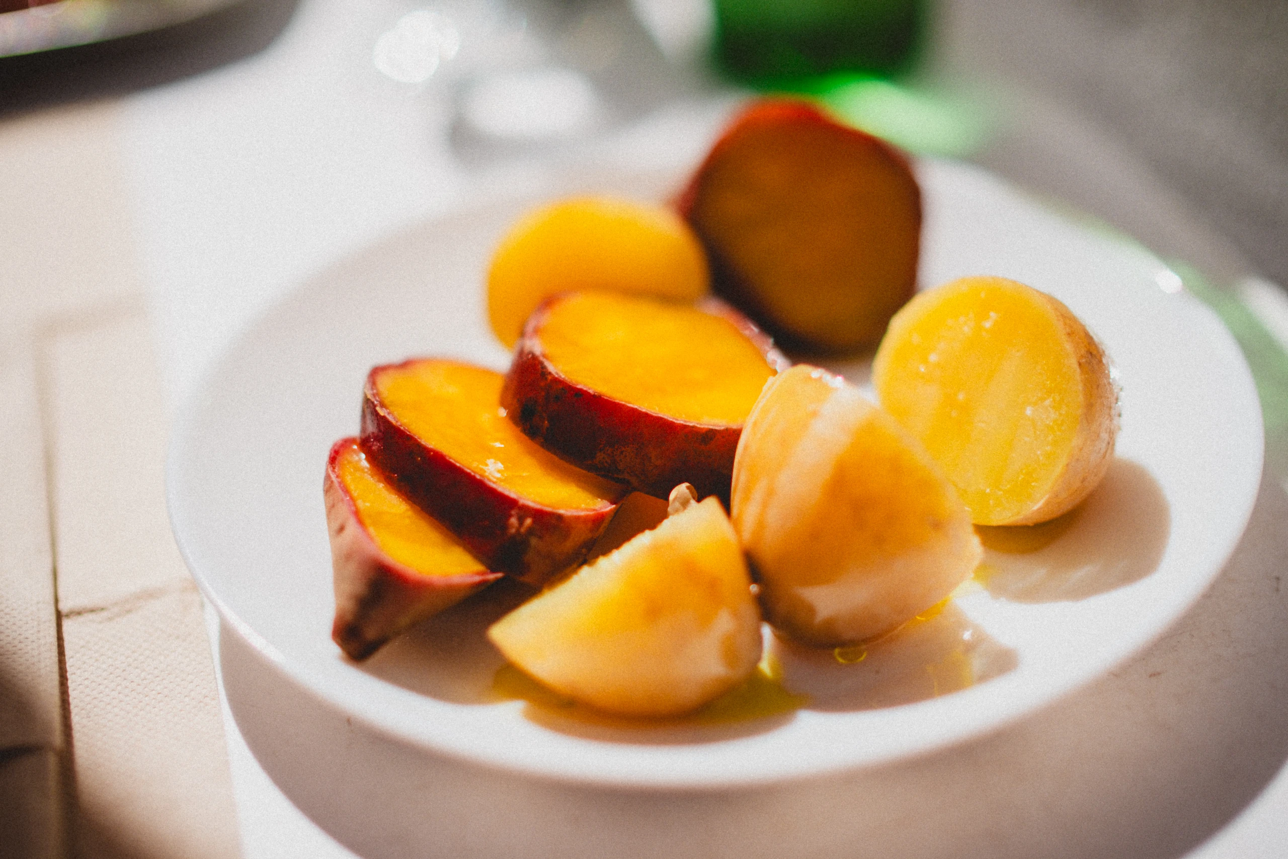 Sliced yellow stone fruit on a white plate
